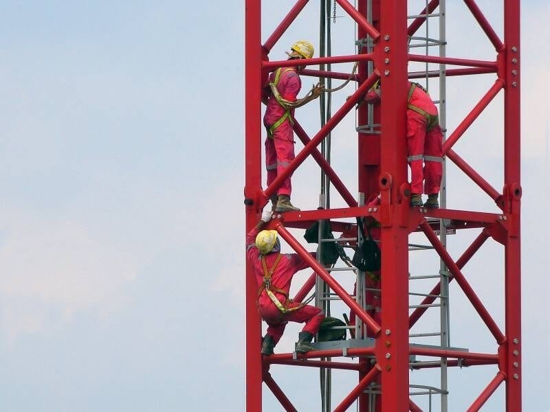 Arbeiten in der Höhe an einer Stahlkonstruktion, koordinierter Einsatz